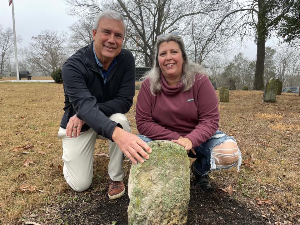 Board members Stan Buke and Mary Smith show off the oldest headstone of a young boy, William Cole, buried in 1806 at Pleasant Forest Cemetery. Jan. 18, 2023.