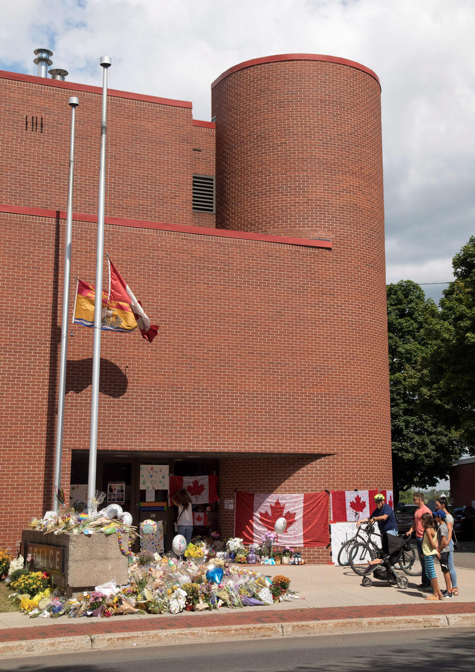 <p>Mourners attend a memorial for Fredericton police constables Sara Burns and Robb Costello at the police station in Fredericton on Thursday, Aug. 16, 2018. (Photo from The Canadian Press/Keith Minchin </p>