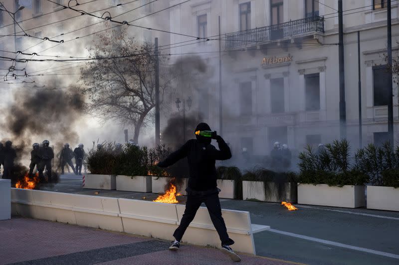 A protester throws a petrol bomb as Greek university students clash with riot police during a demonstration against government plans to set up university police, amid the coronavirus disease (COVID-19) pandemic, in Athens