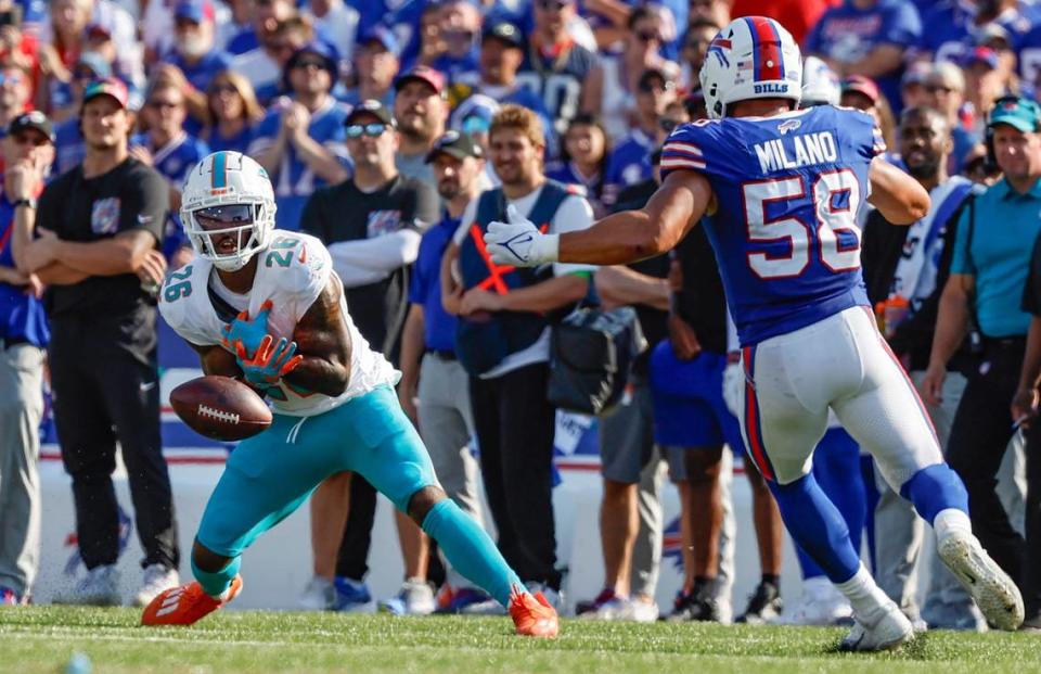 El running back de los Dolphins Salvon Ahmed (26) pierde un pase ante la marca del linebacker de Buffalo Bills Matt Milano, en el partido celebrado el 1ro de octubre de 2023 en Orchard Park, Nueva York.