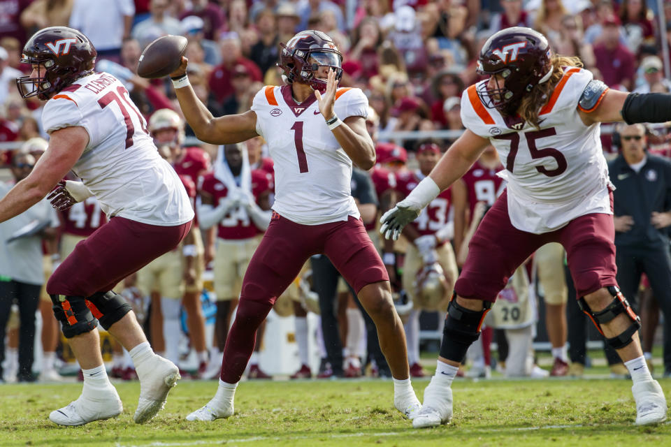 Virginia Tech quarterback Kyron Drones (1) is protected by Virginia Tech offensive lineman Parker Clements (70) and Virginia Tech offensive lineman Bob Schick (75) as he looks for a receiver during the first half of an NCAA college football game, Saturday, Oct. 7, 2023, in Tallahassee, Fla. (AP Photo/Colin Hackley)