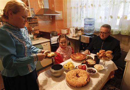 Russian Cossack Alexander Kriventsev (R), his wife Svetlana (L) and their daughter Anna have a traditional meal at home in the southern Russian city of Volgograd, January 6, 2014. REUTERS/Vasily Fedosenko