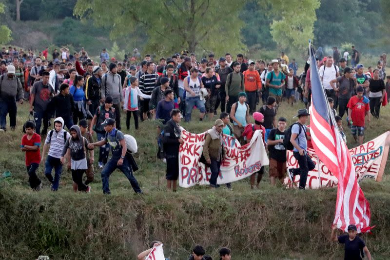 Migrants, mainly from Central America and marching in a caravan, walk after crossing the Suchiate river, on the outskirts of Ciudad Hidalgo