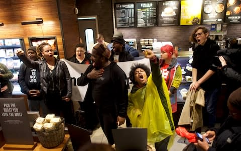 Protestors demonstrate inside a Center City Starbucks, where two black men were arrested, in Philadelphia - Credit: REUTERS/Mark Makela