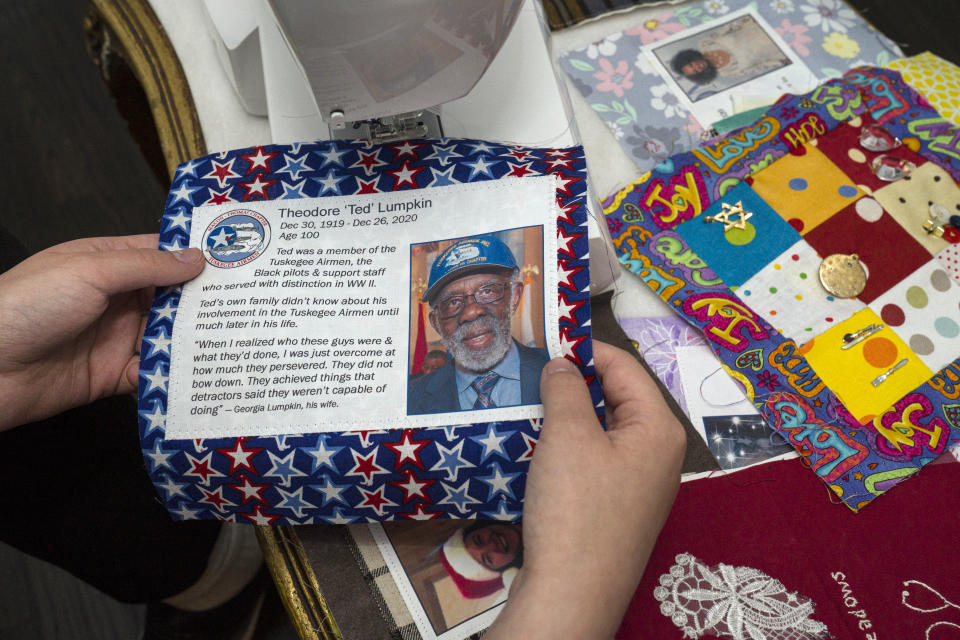 High school freshman Madeleine Fugate holds a picture of late Tuskegee Airman Theodore "Ted" Lumpkin to be included in one of her quilts, part of the COVID Memorial Quilt to honor and remember those who died of COVID-19, at her home in Los Angeles. Fugate's memorial quilt started out in May 2020 as a seventh grade class project. Inspired by the AIDS Memorial Quilt, which her mother worked on in the 1980s, the then-13-year-old encouraged families in her native Los Angeles to send her fabric squares representing their lost loved ones that she'd stitch together. (AP Photo/Damian Dovarganes)