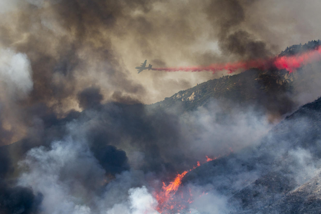 An air tanker drops retardant at a wildfire burns at a hillside in Yucaipa, Calif., Saturday, Sept. 5, 2020.  (AP Photo/Ringo H.W. Chiu)
