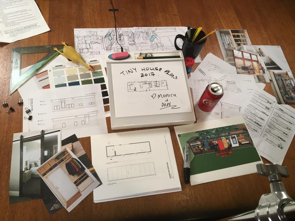 pile of paper and binders organizing the tiny house building plans