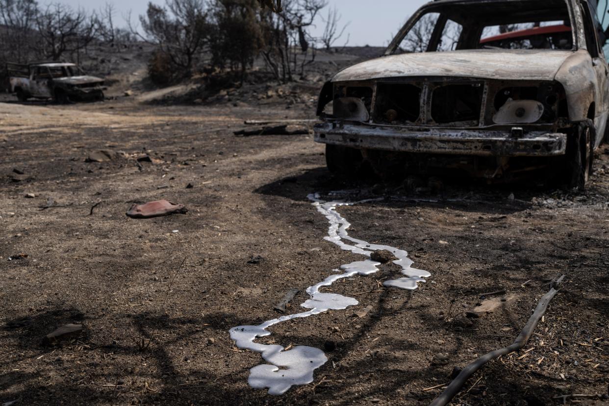 Burnt cars are seen after a wildfire near Gennadi village, on the Aegean Sea island of Rhodes (AP)