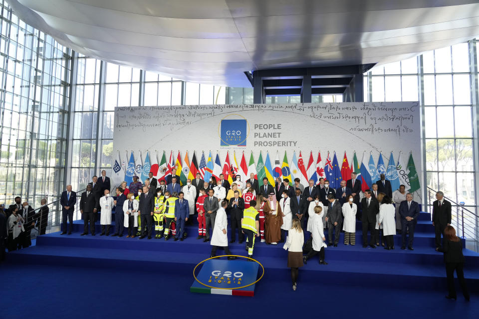 Medical personnel walk onto the stage for a group photo with world leaders at the La Nuvola conference center for the G20 summit in Rome, Saturday, Oct. 30, 2021. The two-day Group of 20 summit is the first in-person gathering of leaders of the world's biggest economies since the COVID-19 pandemic started. (AP Photo/Gregorio Borgia)