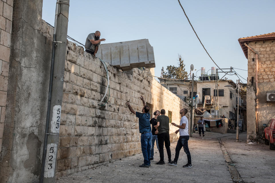 At the mosque in the old city center of Lod, young Palestinians gather on the roof to prepare their defense before expected clashes on May 12, 2021.<span class="copyright">Laurent Van Der Stockt—Getty Images</span>