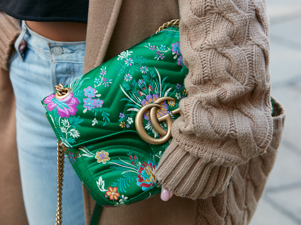 Frau mit grüner, geblümter Gucci-Tasche auf der Straße