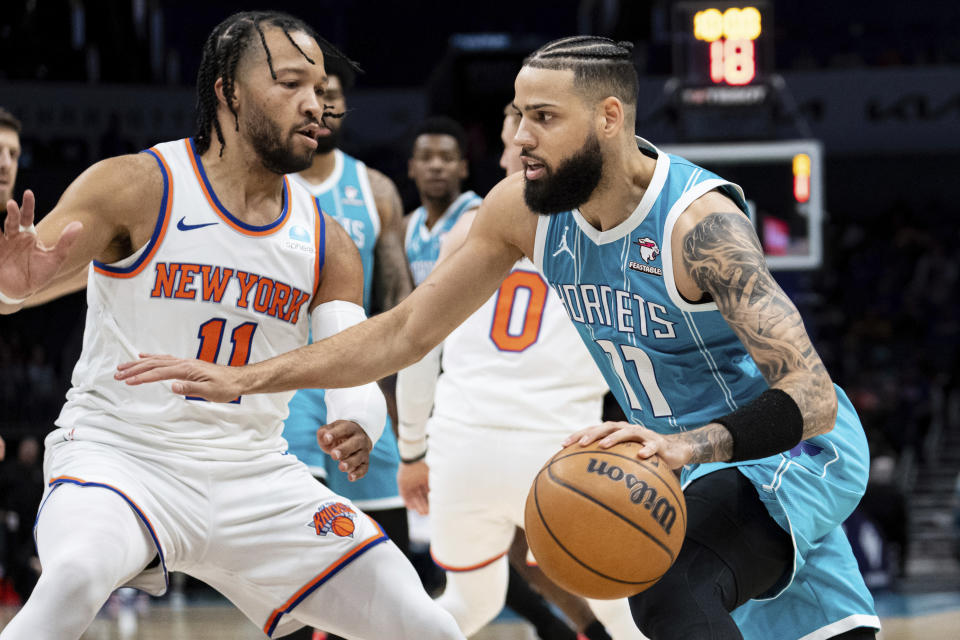 Charlotte Hornets forward Cody Martin, right, drives to the basket while guarded by New York Knicks guard Jalen Brunson, left, during the first half of an NBA basketball game Monday, Jan. 29, 2024, in Charlotte, N.C. (AP Photo/Jacob Kupferman)