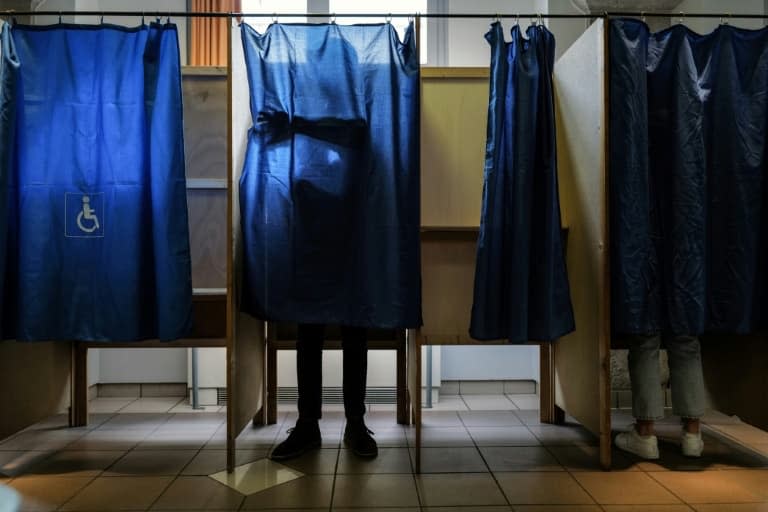 Des électeurs préparent leurs bulletins de vote dans un isoloir à Lyon pour le deuxième tour de la présidentielle, le 24 avril 2022 - OLIVIER CHASSIGNOLE © 2019 AFP