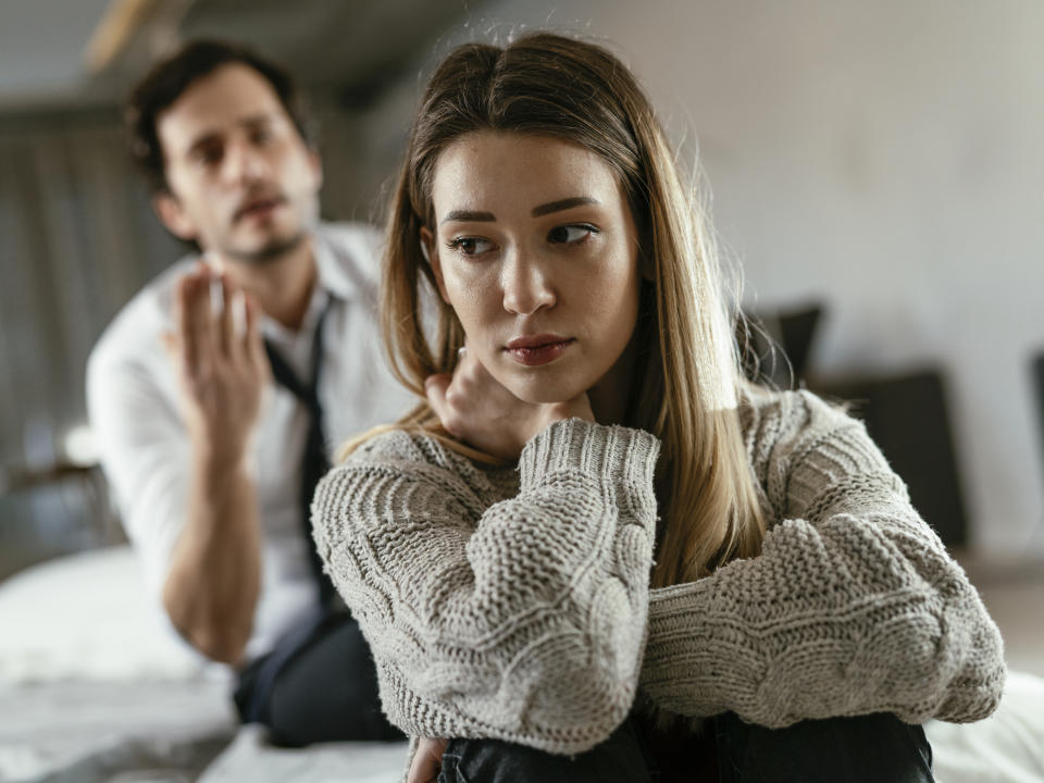 A man and a woman having a serious conversation; the woman appears upset and contemplative