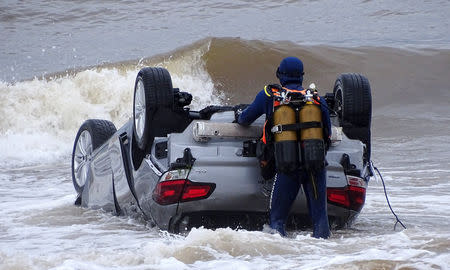 Police divers examine a turned-over car in the sea off Sainte Maxime beach, France October 11, 2018 in this image obtained from social media. Alexandre Houisse via REUTERS