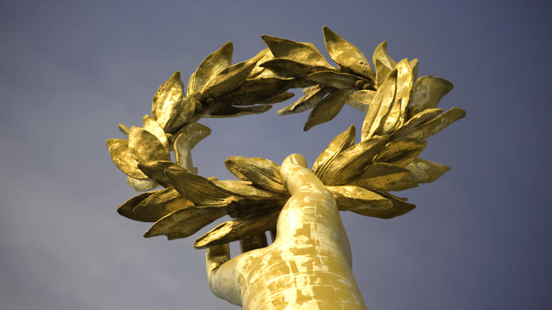 Statue of a hand holding a laurel wreath