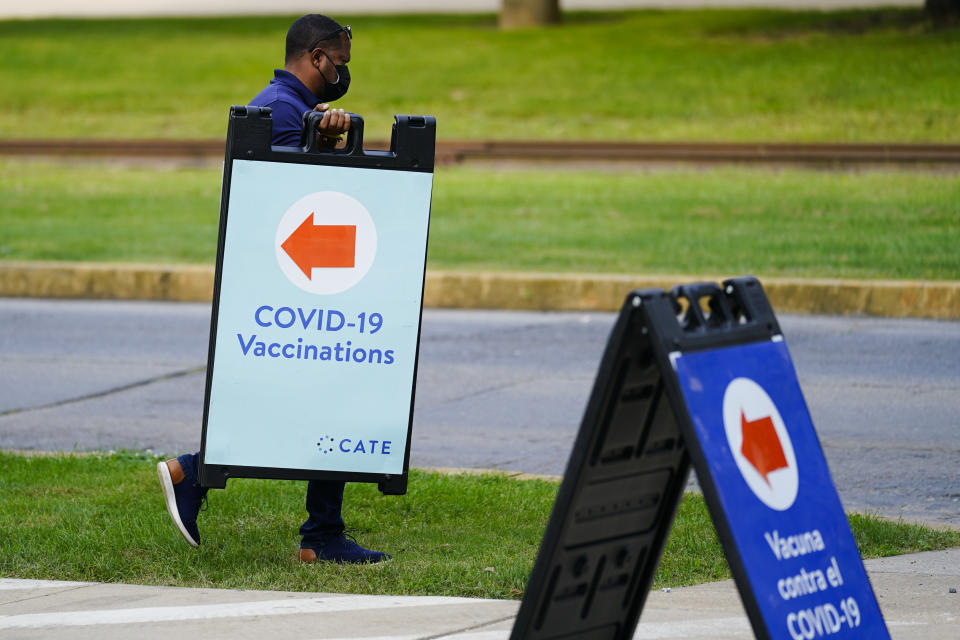 A worker posts placard for a COVID-19 vaccination clinic at the Reading Area Community College in Reading, Pa., Tuesday, Sept. 14, 2021. (AP Photo/Matt Rourke)