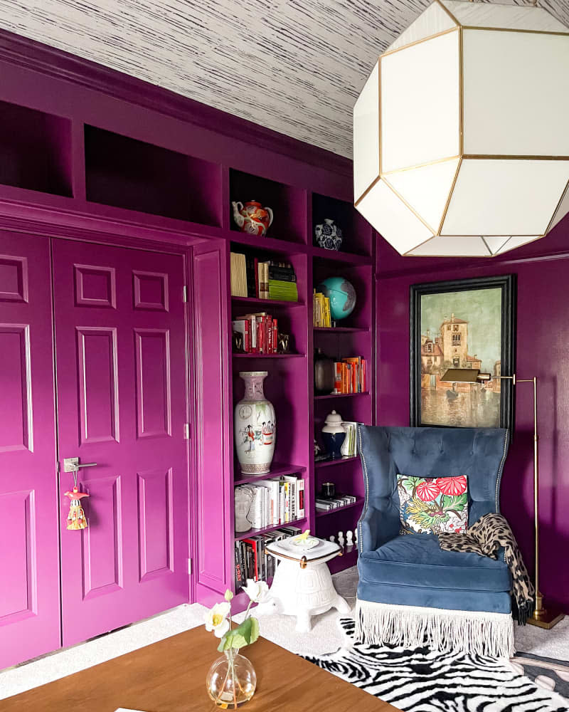 Magenta painted walls with built in shelves in newly remodeled library.