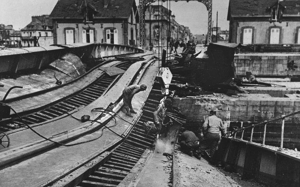 Soldiers repair a destroyed railway bridge in Normandy during WW2