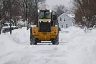 A payloader helps with snow removal after a winter storm rolled through Western New York Tuesday, Dec. 27, 2022, in Amherst, N.Y. (AP Photo/Jeffrey T. Barnes)