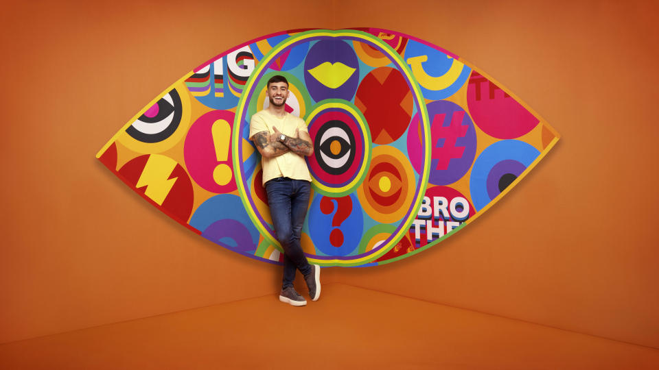 Paul in front of the Big Brother logo.