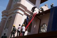 A damaged window is seen as security personnel investigate at St. Sebastian Catholic Church, after bomb blasts ripped through churches and luxury hotels on Easter, in Negombo, Sri Lanka April 22, 2019. REUTERS/Athit Perawongmetha