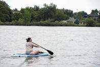 Bekka Hamburg paddle boards on Sloan's Lake in Denver on Wednesday, June 16, 2021. A heat wave continues to hover over the western U.S., pushing the temperature to 99 degrees in Denver. Hamburg, visiting from Indianapolis, said she rented the paddle board a week ago when she saw the forecast. (AP Photo/Brittany Peterson)