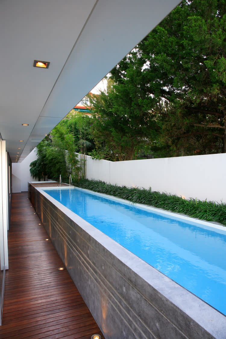 Long, minimalist rectangular pool built into the narrow courtyard of a modern home