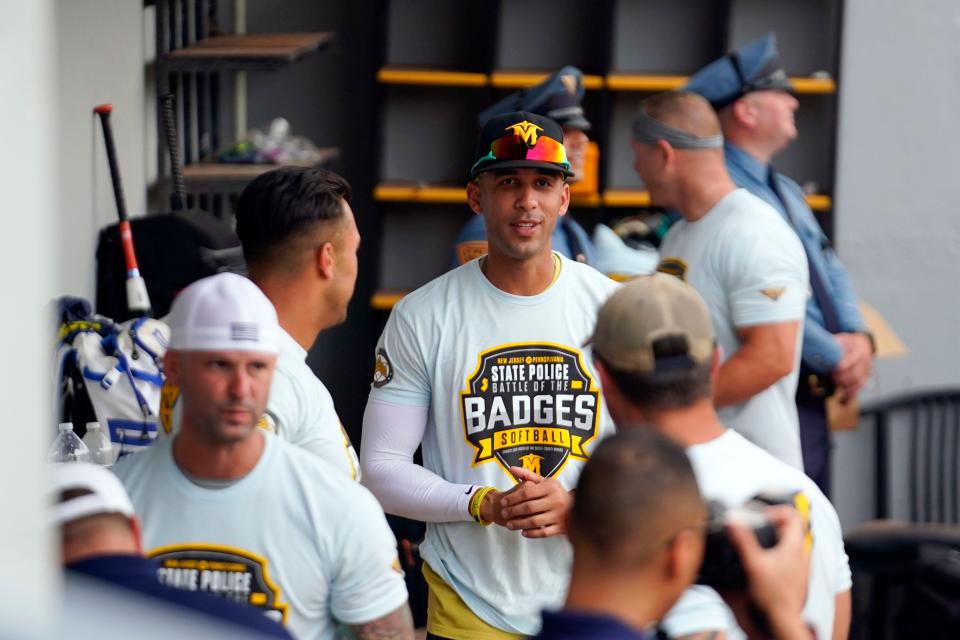 New Jersey State Police Detective Miguel Hidalgo, center, in the dugout for the Battle of the Badges charity softball game at Skylands Stadium on Thursday, August 3, 2023. Hidalgo, who signed a one-day contract with the Sussex County Miners, is donating his salary to help purchase a specialized wheelchair for an 11-year-old boy.