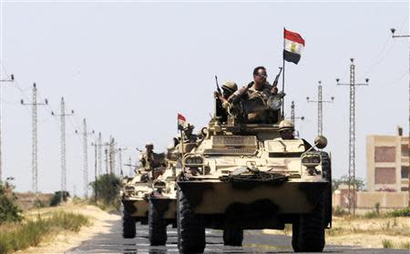 Soldiers in military vehicles proceed towards the al-Jura district in El-Arish city from Sheikh Zuwaid, around 350 km (217 miles) northeast of Cairo in this May 21, 2013 file photo. REUTERS/Stringer