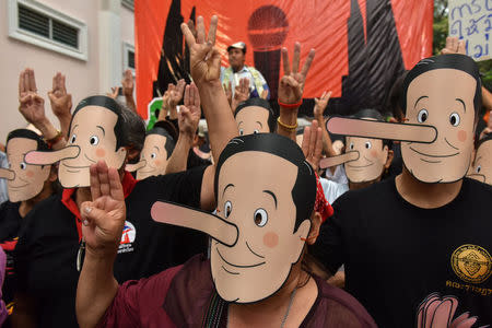 Pro-democracy activists wearing masks mock Thailand's Prime Minister Prayuth Chan-ocha as Pinocchio during a protest against junta at a university in Bangkok, Thailand, February 24, 2018. REUTERS/Panumas Sanguanwong