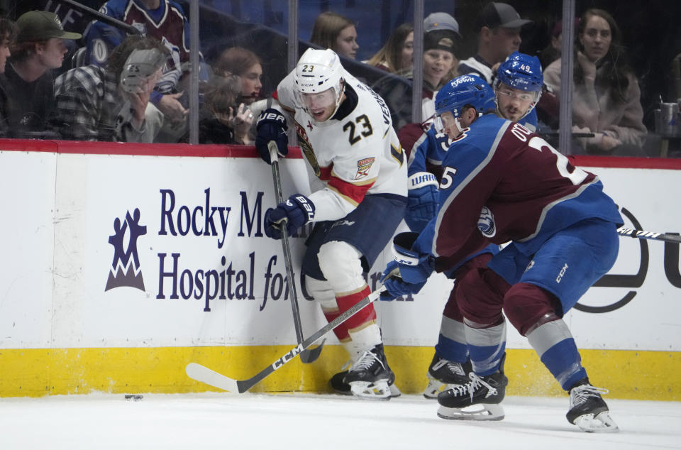 Florida Panthers center Carter Verhaeghe, left, fights for control of the puck as Colorado Avalanche right wing Logan O'Connor, front right, and defenseman Samuel Girard cover in the second period of an NHL hockey game Saturday, Jan. 6, 2024, in Denver. (AP Photo/David Zalubowski)