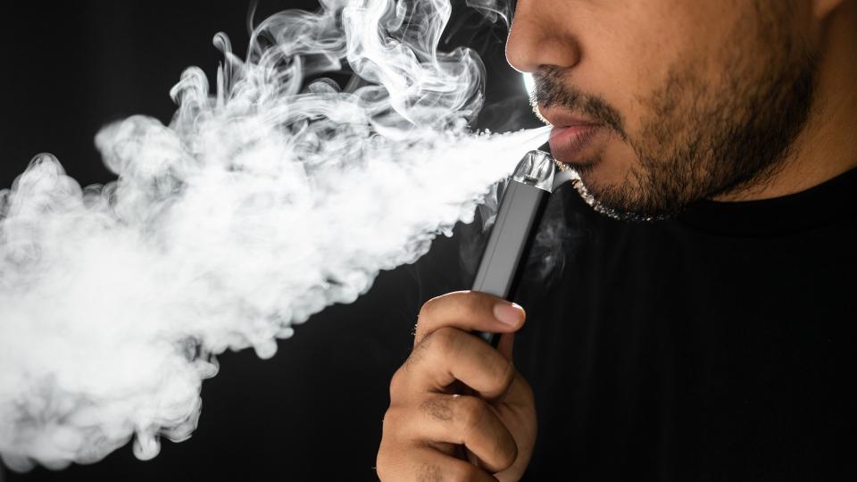 Close-up mouth of man smoke inhaling, breathing and smoke electronic cigarette.