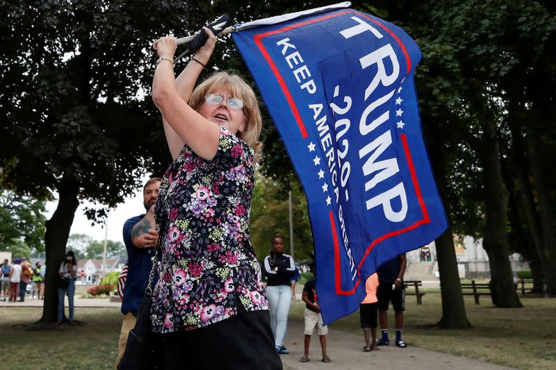 Una partidaria del presidente de Estados Unidos, Donald Trump, agita una bandera en el parque del Centro Cívico durante su visita a Kenosha, Wisconsin, Estados Unidos.