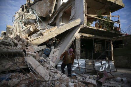 A person inspects damaged building in the besieged town of Douma, Eastern Ghouta, Damascus, Syria February 20, 2018. REUTERS/Bassam Khabieh