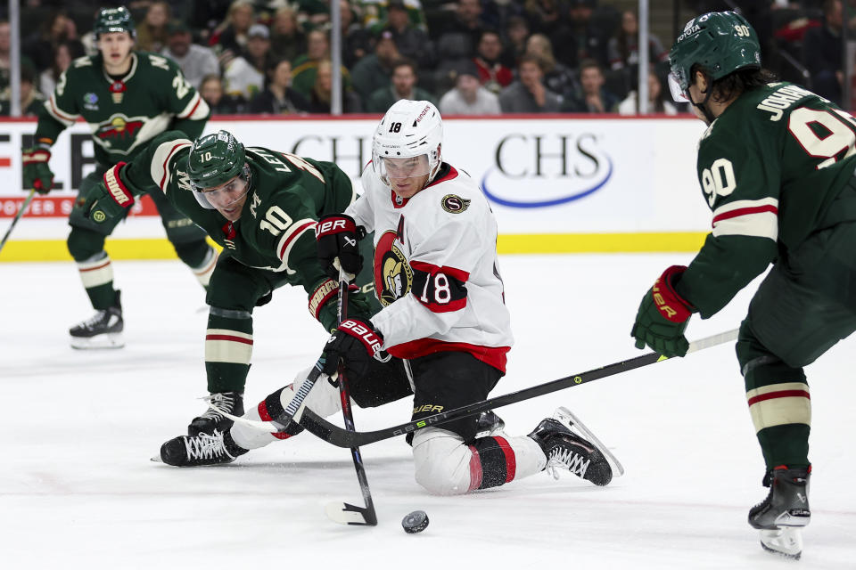 Ottawa Senators center Tim Stutzle, middle, skates with the puck as Minnesota Wild center Vinni Lettieri (10) and center Marcus Johansson defend during the second period of an NHL hockey game Tuesday, April 2, 2024, in St. Paul, Minn. (AP Photo/Matt Krohn)