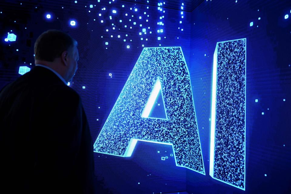 A visitor watches an AI (Artificial Intelligence) sign on an animated screen at the Mobile World Congress (MWC), the telecom industry's biggest annual gathering, in Barcelona.  Photographer: Josep Lago/AFP/Getty Images