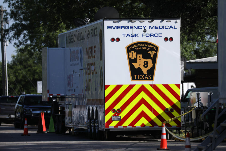 A large white trailer labeled: Emergency Medical Task Force Texas is parked on the street near orange cones and other vehicles.