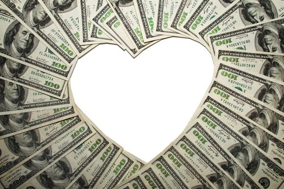 $100 bills arranged to outline a heart shape in the center