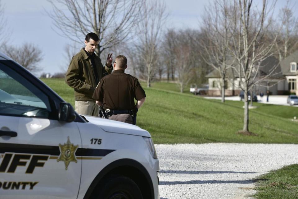 A Tazewell County Sheriff's deputy talks with a man in the home of Reinking's extended family (AP)