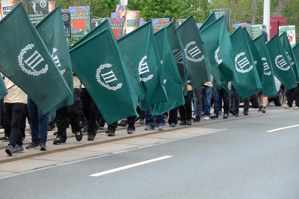 Protestors march with flags during a demonstration of the far-right party 'The third way' in Plauen, Germany, Wednesday, May 1, 2019. (Sebastian Willnow/dpa via AP)