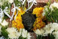 Flowers are placed over a monument to remember the victims of the massacre of pro-democracy students by state forces at Thammasat University on its 44th anniversary, in Bangkok