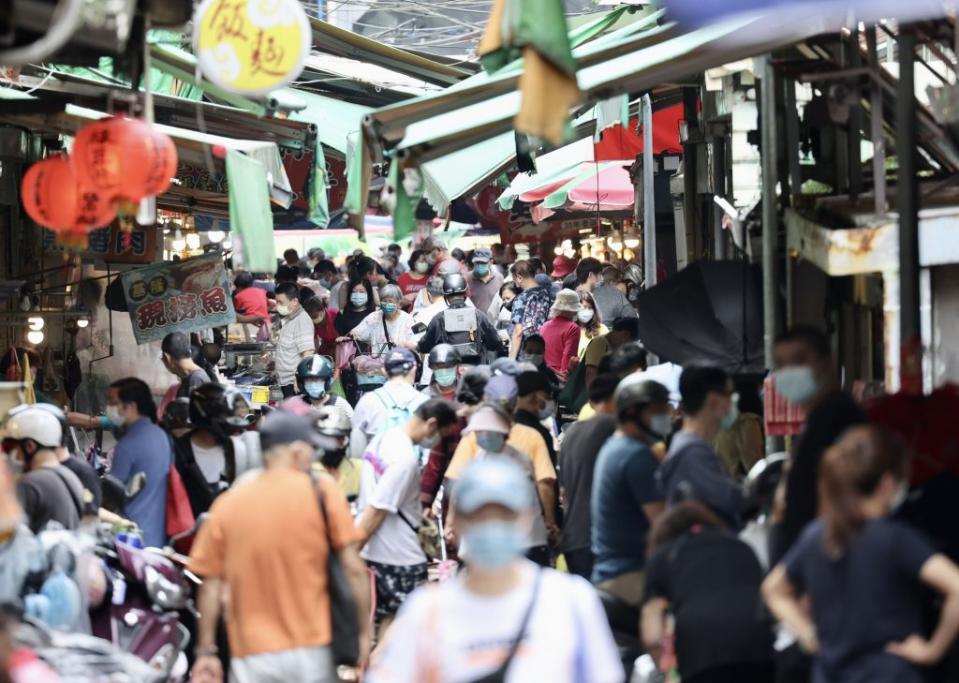 流行疫情指揮中心宣布，6月15日起抵台的航班旅客，居家檢疫將從7天減為3天，並進行4天自主防疫。圖為台北市萬華區傳統市場上午湧現人潮，不少民眾趁著週末假日戴口罩到市場採買。（中央社）