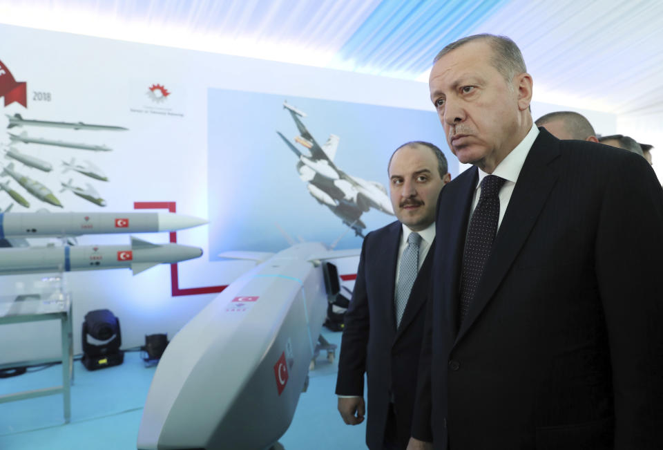 Turkey's President Recep Tayyip Erdogan, right, listens to Technology Minister Mustafa Varank at a defence technology development meeting, in Ankara, Turkey, Wednesday, Oct. 31, 2018. Turkey's state-run news agency says the Turkish military has shelled positions held by U.S.-backed Kurdish fighters across the border east of the Euphrates River in Syria, killing four Kurdish fighters and wounding six others. The attack came a day after Erdogan said Turkey has finalized plans for a "comprehensive and effective" operation to drive out Kurdish militia from the region.(Presidential Press Service via AP, Pool)