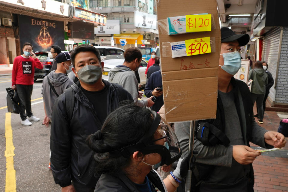 Customers wearing face masks queue up to purchase COVID-19 antigen test kits at a market in Hong Kong, Monday, Feb. 28, 2022. (AP Photo/Vincent Yu)