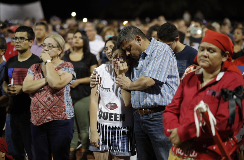 People comfort each other during a vigil for victims of Saturday's mass shooting at the shopping complex in El Paso. (AP)