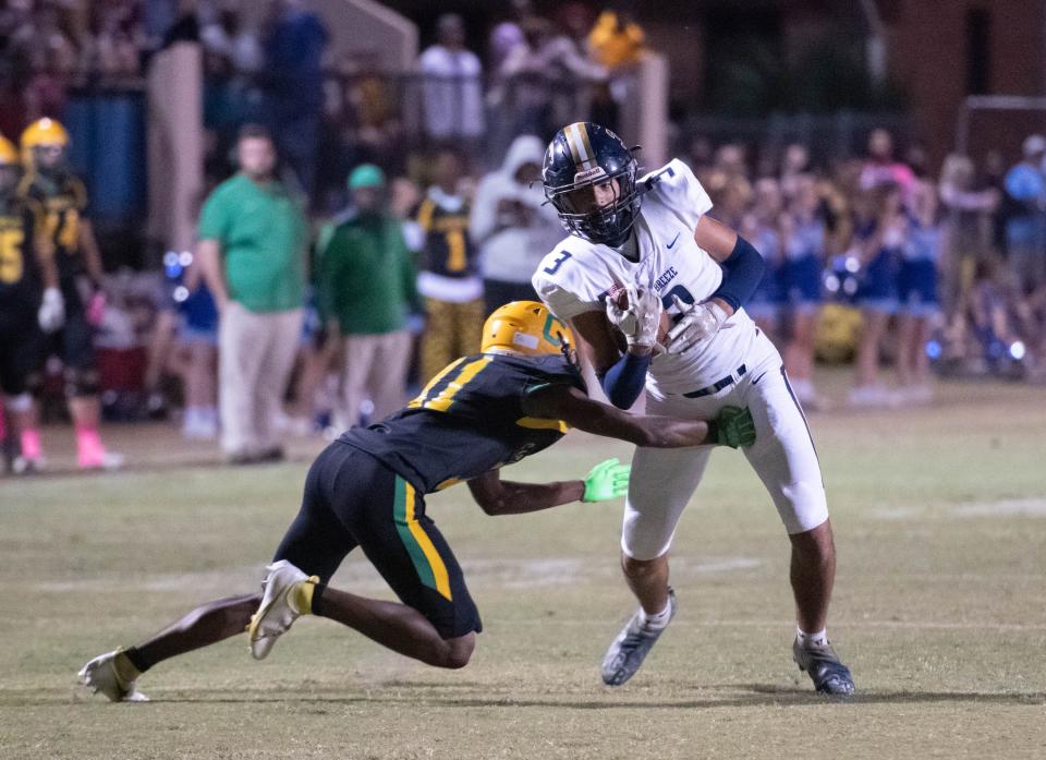 Kohen Kember (3) slips past the tackle attempt by Xavier Thompson (11) during the Gulf Breeze vs Catholic football game at Pensacola Catholic High School in Pensacola on Thursday, Oct. 6, 2022.