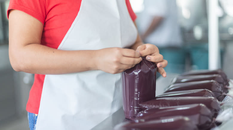 person sealing acai pulp bag