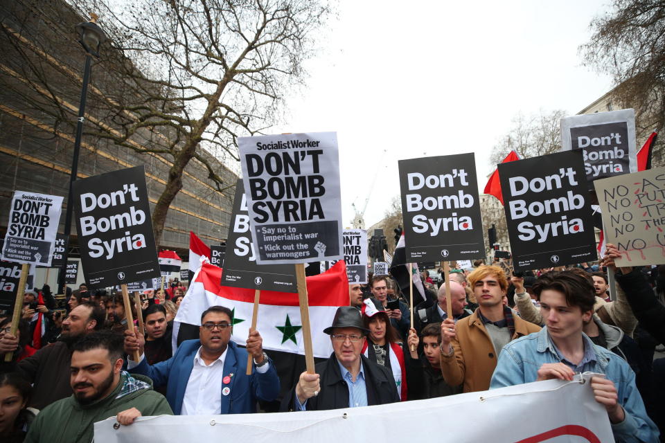 Anti-war activists hold placards outside Downing Street (PA)