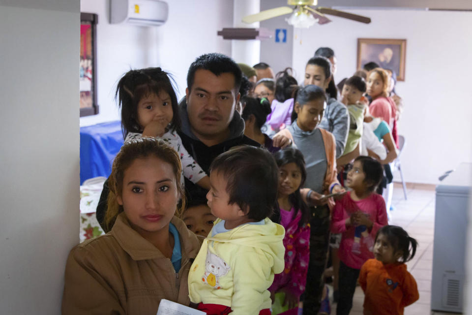 Foto del 28 de enero del 2020 suministrada por Cronkite News, de la Universidad Estatal de Arizona, que muestra personas con hijos haciendo cola para ser vacunados en la Casa del Migrante de San Luis Río Colorado, México. Una organización de Phoenix decidió vacunar a migrantes del lado mexicano de la frontera en vista de que el gobierno de EEUU se resiste a hacerlo en sus centros de detención. (Delia Johnson/Cronkite News, Arizona State University via AP)